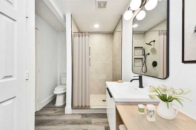5817 Beechnut St, Houston, TX 77074 - full bathroom featuring vanity, wood finished floors, tiled shower, and recessed lighting