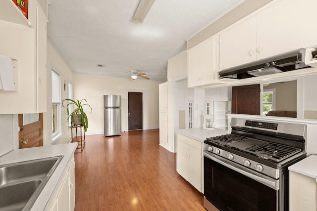 213 E Feagin St, Livingston, TX 77351 - kitchen featuring appliances with stainless steel finishes, under cabinet range hood, light countertops, and white cabinets
