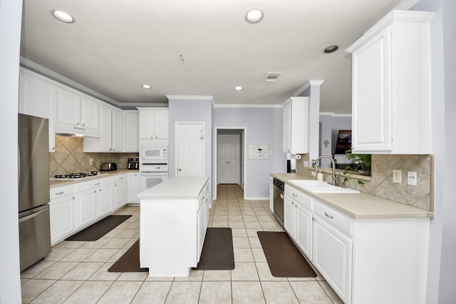 2613 Broussard Ct, Seabrook, TX 77586 - kitchen with stainless steel appliances, under cabinet range hood, a kitchen island, crown molding, and light countertops