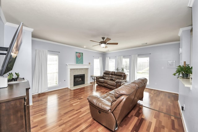 2613 Broussard Ct, Seabrook, TX 77586 - living area featuring a ceiling fan, a tile fireplace, light wood finished floors, healthy amount of natural light, and crown molding