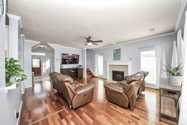 2613 Broussard Ct, Seabrook, TX 77586 - living area with light wood-style floors, a tile fireplace, a ceiling fan, and crown molding