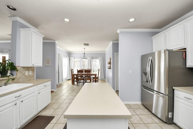 2613 Broussard Ct, Seabrook, TX 77586 - kitchen featuring stainless steel fridge, light tile patterned floors, tasteful backsplash, white cabinetry, and crown molding