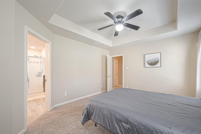 2335 Village Leaf Dr, Spring, TX 77386 - carpeted bedroom with a tray ceiling, ensuite bathroom, and ceiling fan