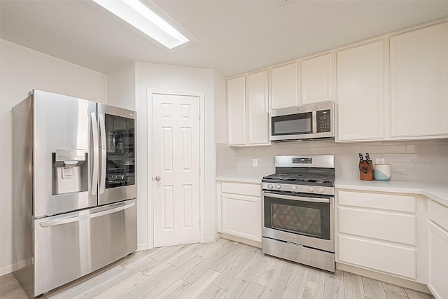 2335 Village Leaf Dr, Spring, TX 77386 - kitchen featuring stainless steel appliances, light countertops, backsplash, light wood-style floors, and white cabinets