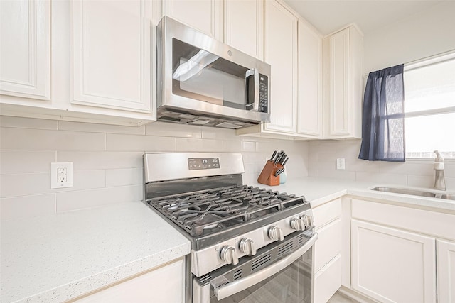 2335 Village Leaf Dr, Spring, TX 77386 - kitchen featuring stainless steel appliances, light countertops, decorative backsplash, and white cabinets
