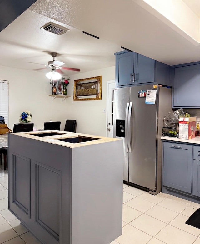 7722 Breezeway St, Houston, TX 77040 - kitchen featuring stainless steel fridge, light tile patterned floors, ceiling fan, gray cabinets, and light countertops