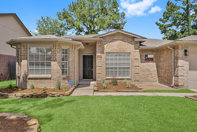 29222 Waltham St, Spring, TX 77386 - doorway to property featuring an attached garage, a lawn, brick siding, and roof with shingles