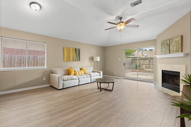 29222 Waltham St, Spring, TX 77386 - living room featuring wood finished floors, ceiling fan, a textured ceiling, and a premium fireplace