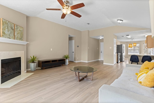 29222 Waltham St, Spring, TX 77386 - living area featuring vaulted ceiling, ceiling fan, light wood finished floors, and a fireplace