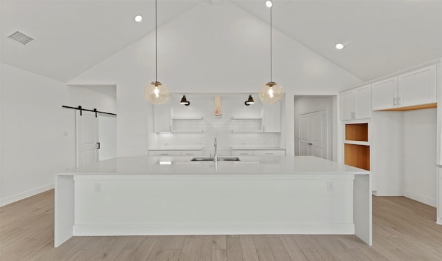 21230 Blue Bluff Dr, Cypress, TX 77433 - kitchen with a barn door, open shelves, high vaulted ceiling, white cabinets, and light countertops