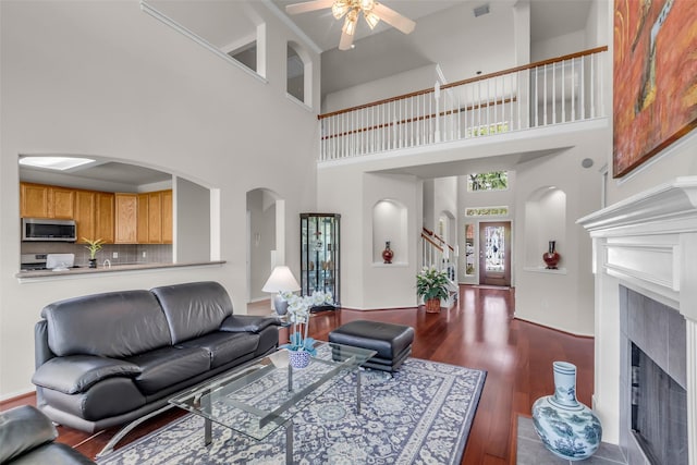 13811 Brannon Field Ln, Houston, TX 77041 - living area featuring a ceiling fan, arched walkways, a high ceiling, a fireplace with flush hearth, and wood finished floors