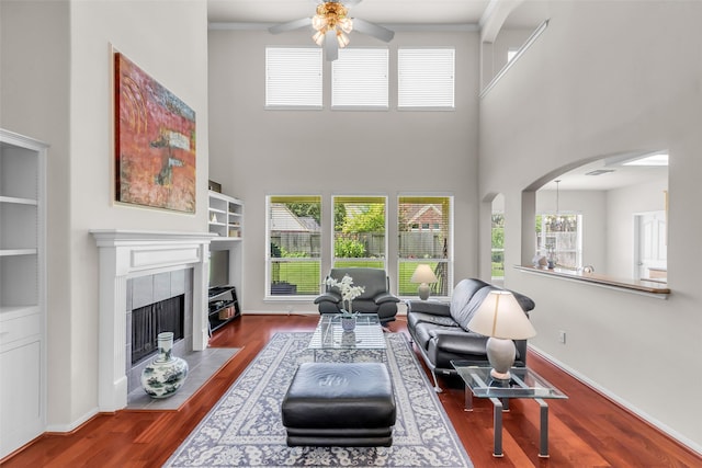 13811 Brannon Field Ln, Houston, TX 77041 - living room with ceiling fan, a high ceiling, wood finished floors, a tile fireplace, and arched walkways