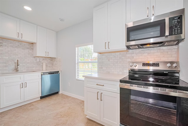 52 Penway St, Houston, TX 77022 - kitchen with appliances with stainless steel finishes, light countertops, white cabinetry, and decorative backsplash