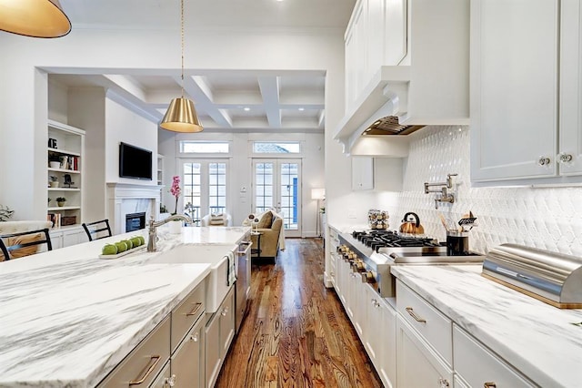 325 W 23rd St, Houston, TX 77008 - kitchen with open floor plan, dark wood-style flooring, beamed ceiling, a glass covered fireplace, and light stone countertops