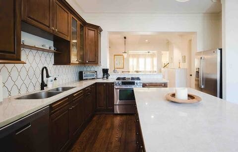 1616 Southmore Blvd, Houston, TX 77004 - kitchen with stainless steel appliances, light countertops, glass insert cabinets, decorative backsplash, and dark wood-style flooring