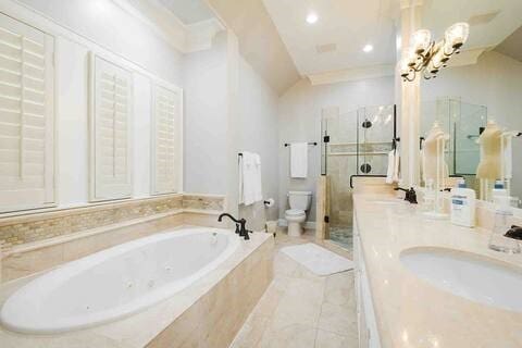 1616 Southmore Blvd, Houston, TX 77004 - bathroom featuring a shower stall, a tub with jets, vanity, a chandelier, and ornamental molding