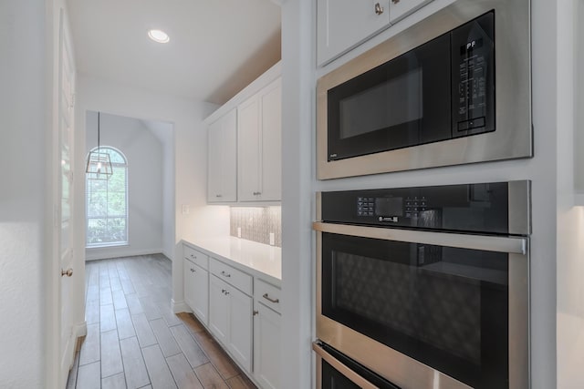 17010 Harpers Way, Conroe, TX 77385 - kitchen featuring built in microwave, stainless steel oven, white cabinetry, light countertops, and recessed lighting