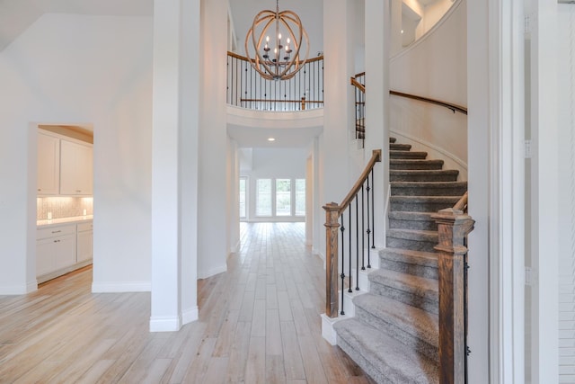 17010 Harpers Way, Conroe, TX 77385 - entrance foyer with light wood finished floors, a towering ceiling, a chandelier, and stairway