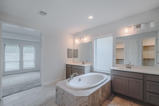 17010 Harpers Way, Conroe, TX 77385 - bathroom featuring healthy amount of natural light, two vanities, a garden tub, a spacious closet, and recessed lighting