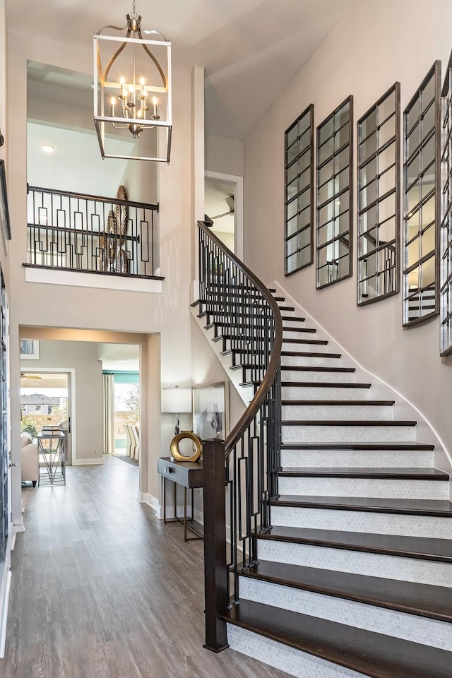 9218 Heckenberg Arbor Ln, Cypress, TX 77433 - stairway featuring a chandelier, wood finished floors, and a high ceiling