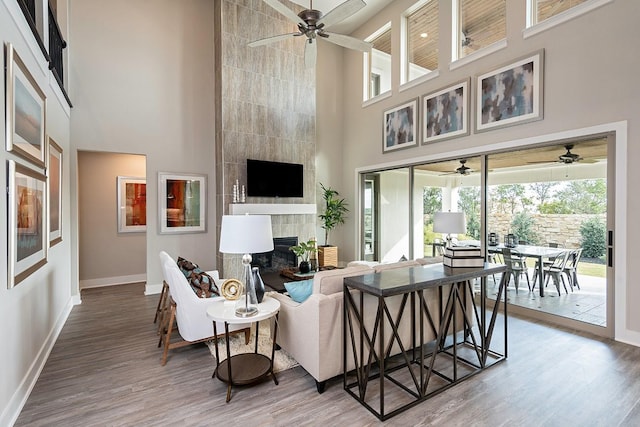 9218 Heckenberg Arbor Ln, Cypress, TX 77433 - living area featuring a high ceiling, ceiling fan, wood finished floors, and a tiled fireplace