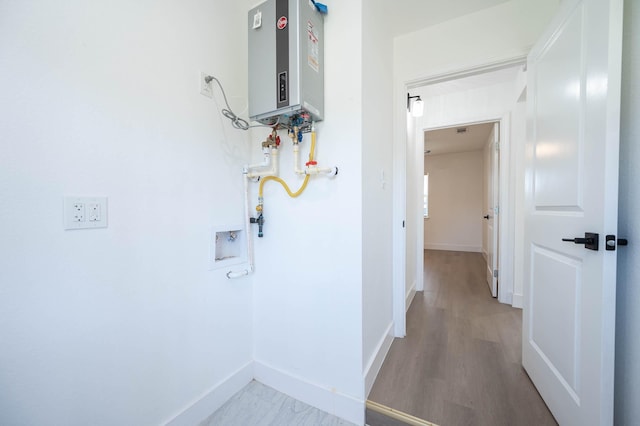 6615 Dewville Ln, Houston, TX 77076 - hall featuring tankless water heater and wood finished floors