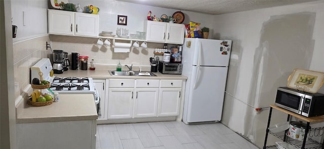 5518 Cochran St, Houston, TX 77009 - kitchen featuring white appliances, white cabinets, light countertops, and light tile patterned floors