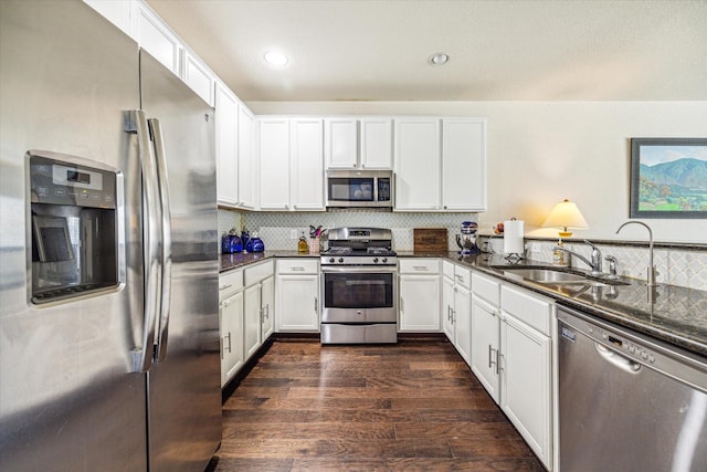 18314 Harvest Star Ct, Houston, TX 77084 - kitchen with stainless steel appliances, dark wood-style flooring, tasteful backsplash, white cabinetry, and recessed lighting