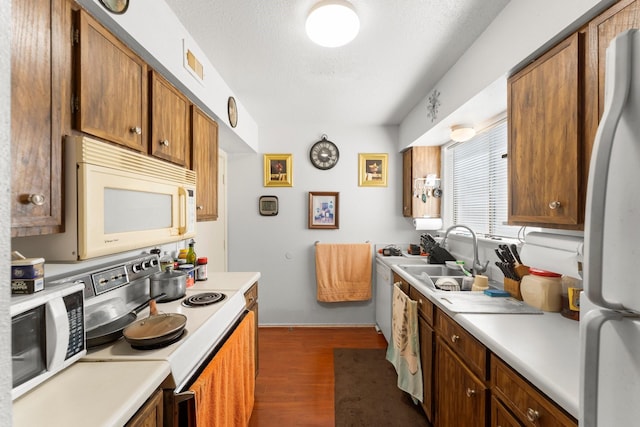 6701 Sands Point Dr Unit 114, Houston, TX 77074 - kitchen with white appliances, dark wood finished floors, light countertops, brown cabinets, and a textured ceiling