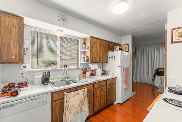6701 Sands Point Dr Unit 114, Houston, TX 77074 - kitchen with white appliances, brown cabinetry, wood finished floors, light countertops, and a textured ceiling