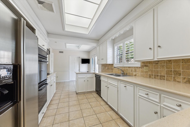 4932 Post Oak Timber Dr, Houston, TX 77056 - kitchen featuring black appliances, light tile patterned floors, light countertops, and decorative backsplash