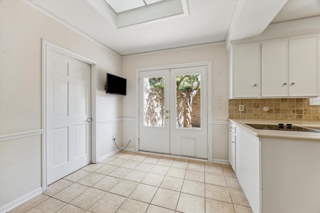 4932 Post Oak Timber Dr, Houston, TX 77056 - kitchen featuring black electric cooktop, white cabinets, light countertops, french doors, and tasteful backsplash