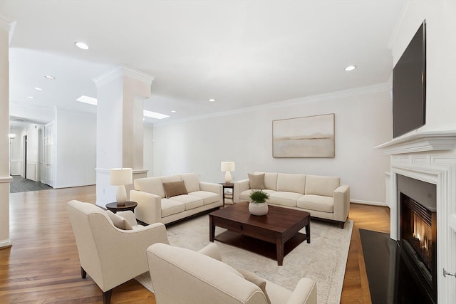 4932 Post Oak Timber Dr, Houston, TX 77056 - living area featuring a glass covered fireplace, light wood-style floors, ornamental molding, recessed lighting, and decorative columns