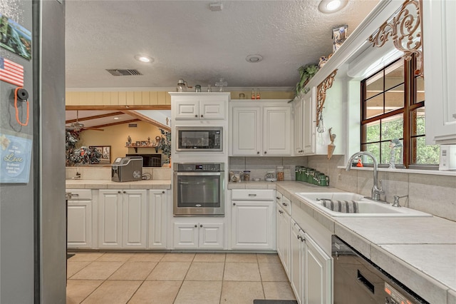 459 Brookwood Dr, Diboll, TX 75941 - kitchen featuring stainless steel oven, built in microwave, a textured ceiling, white cabinets, and dishwasher