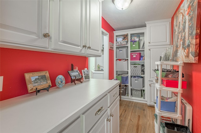 459 Brookwood Dr, Diboll, TX 75941 - kitchen with light wood-type flooring, white cabinetry, light countertops, and a textured ceiling
