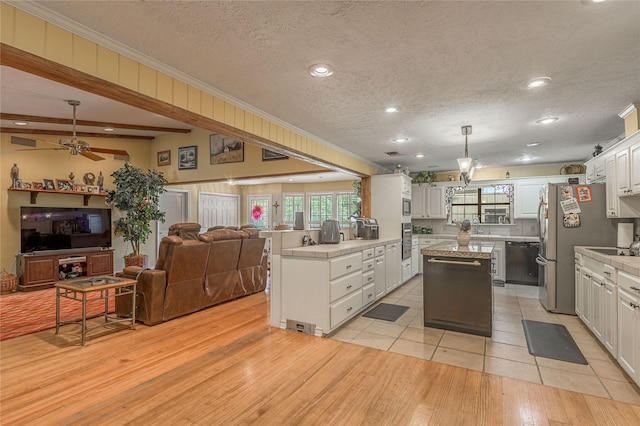 459 Brookwood Dr, Diboll, TX 75941 - kitchen with stainless steel appliances, open floor plan, ornamental molding, a center island, and white cabinetry