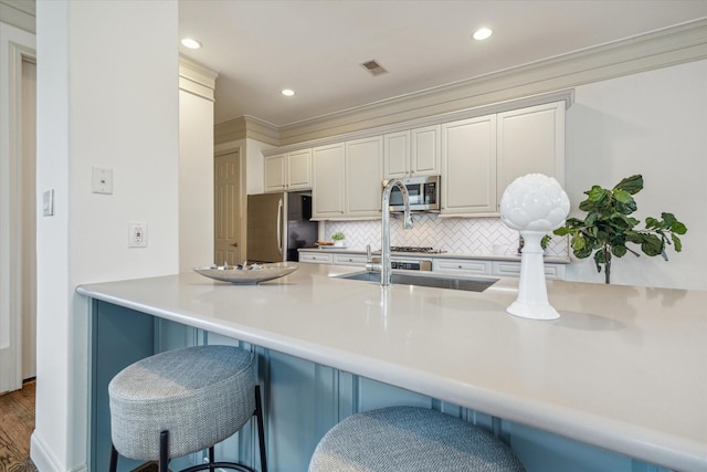 1518 Dunlavy St, Houston, TX 77006 - kitchen with stainless steel appliances, decorative backsplash, a kitchen breakfast bar, recessed lighting, and light countertops