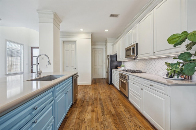 1518 Dunlavy St, Houston, TX 77006 - kitchen featuring blue cabinets, appliances with stainless steel finishes, white cabinetry, decorative backsplash, and recessed lighting
