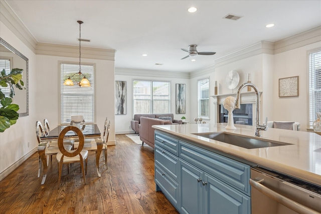 1518 Dunlavy St, Houston, TX 77006 - kitchen with dishwasher, blue cabinetry, a glass covered fireplace, dark wood-type flooring, and crown molding