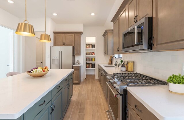 20919 Carriage Harness Way, Tomball, TX 77377 - kitchen featuring appliances with stainless steel finishes, light wood-style flooring, a kitchen island, decorative backsplash, and light countertops
