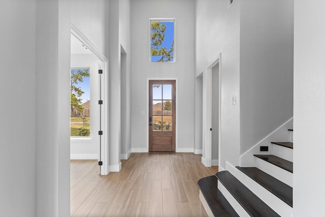 7007 Longmire Cir, Conroe, TX 77304 - foyer entrance with light wood-style flooring, a high ceiling, and stairs