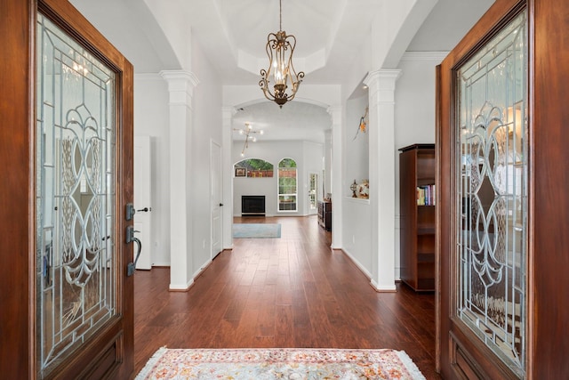 6531 Glenhill Dr, Spring, TX 77389 - foyer featuring decorative columns, dark wood-style flooring, a chandelier, a raised ceiling, and crown molding