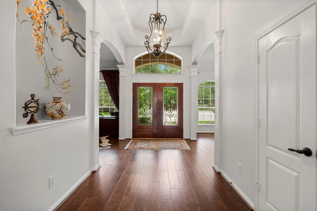 6531 Glenhill Dr, Spring, TX 77389 - entrance foyer with arched walkways, ornate columns, dark wood-style flooring, and a tray ceiling