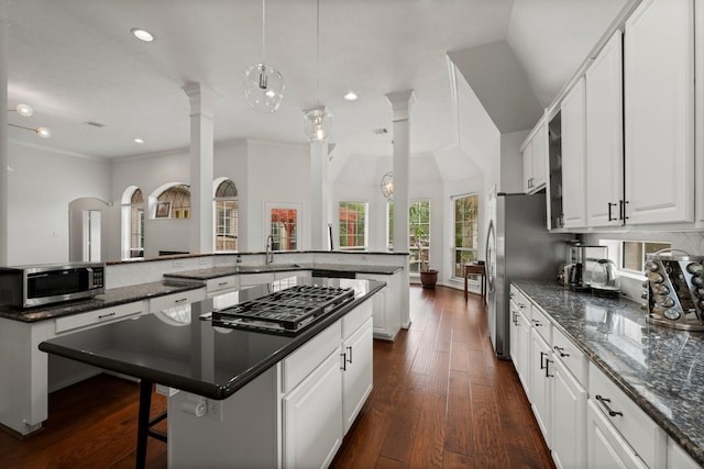 6531 Glenhill Dr, Spring, TX 77389 - kitchen featuring stainless steel appliances, a large island, a kitchen breakfast bar, white cabinets, and dark wood finished floors