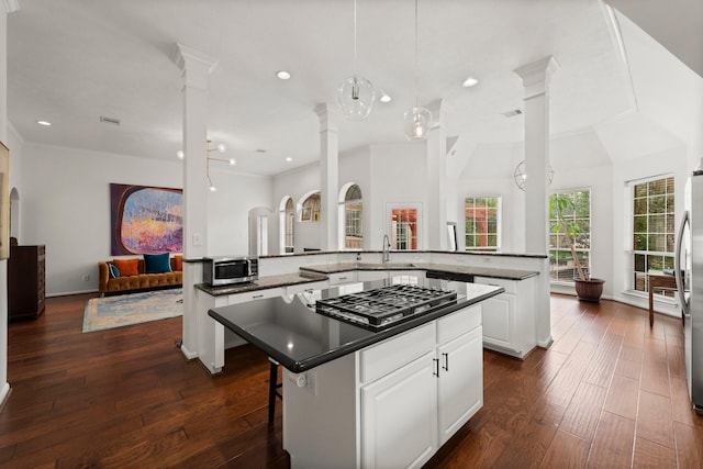 6531 Glenhill Dr, Spring, TX 77389 - kitchen with appliances with stainless steel finishes, a kitchen island, decorative columns, dark countertops, and open floor plan