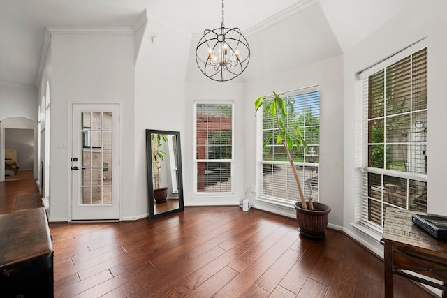 6531 Glenhill Dr, Spring, TX 77389 - unfurnished dining area featuring crown molding, arched walkways, dark wood-style flooring, and a chandelier