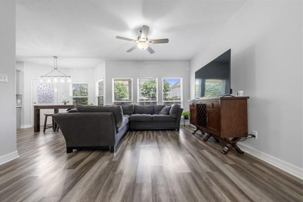 19602 Hardwood Ridge Trl, Cypress, TX 77429 - living room with wood finished floors, a ceiling fan, and a chandelier