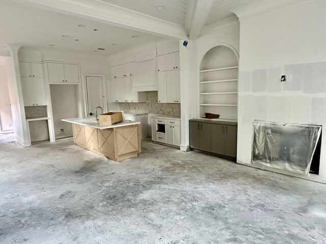 2434 Quenby St, Houston, TX 77005 - kitchen with unfinished concrete flooring, beam ceiling, a kitchen island, backsplash, and white cabinets
