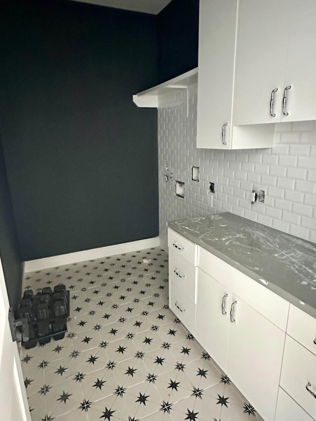 2434 Quenby St, Houston, TX 77005 - kitchen featuring tasteful backsplash, dark stone countertops, and white cabinetry