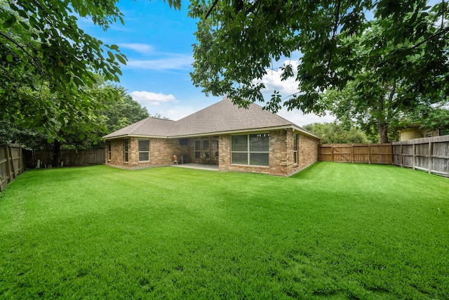 12311 Hawthorne Dr, Montgomery, TX 77356 - rear view of house with a fenced backyard, brick siding, and a shingled roof